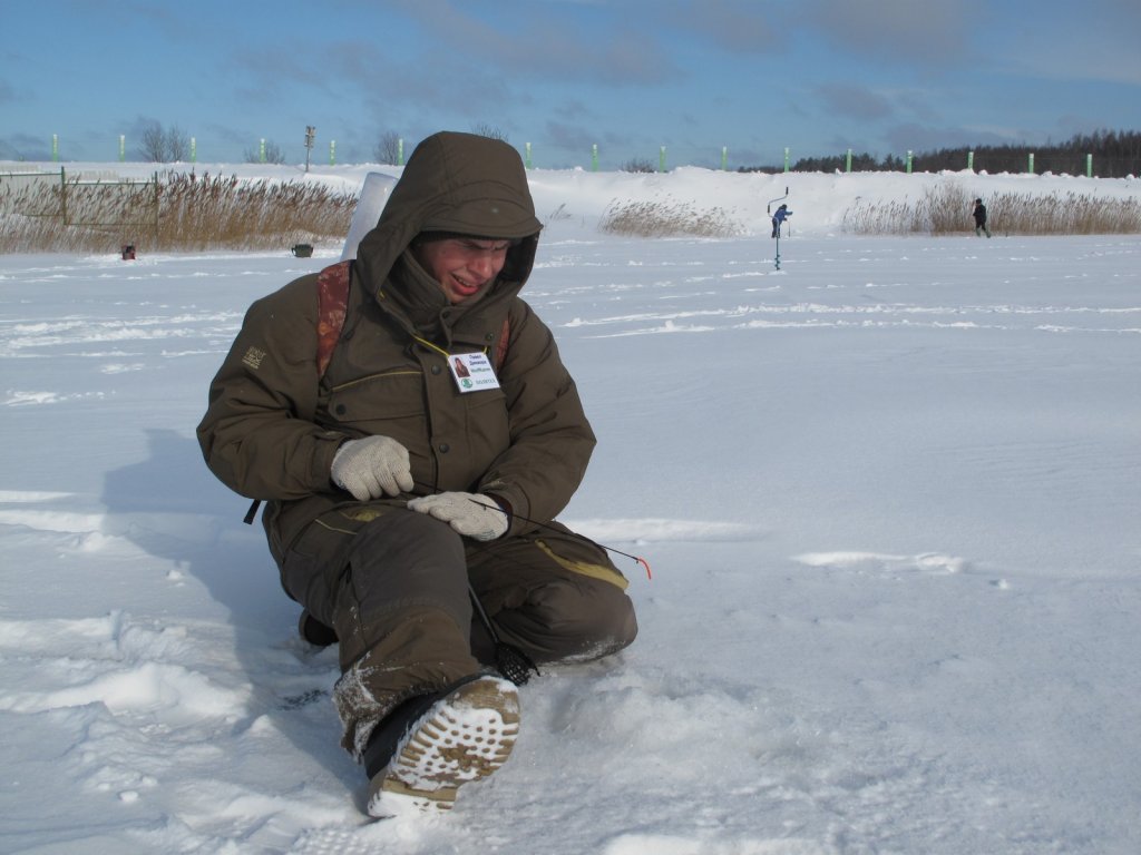 Рыболов ловит сидя на льду Рыболов ловит сидя на льду
