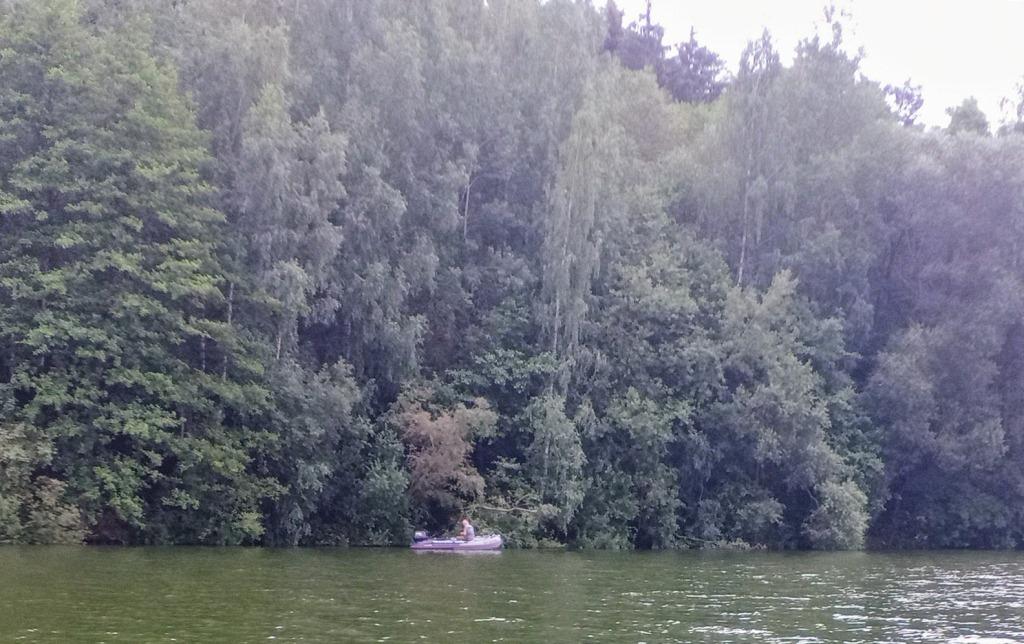 Рыбалка на лодке Рыбак в лодке на фоне леса
