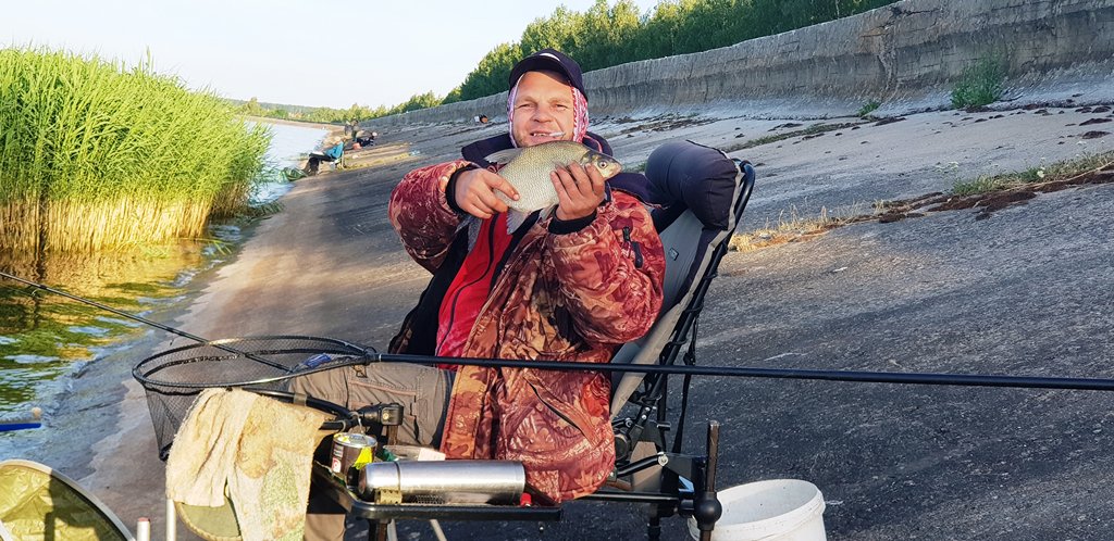 Небольшой лещ в руках рыболова