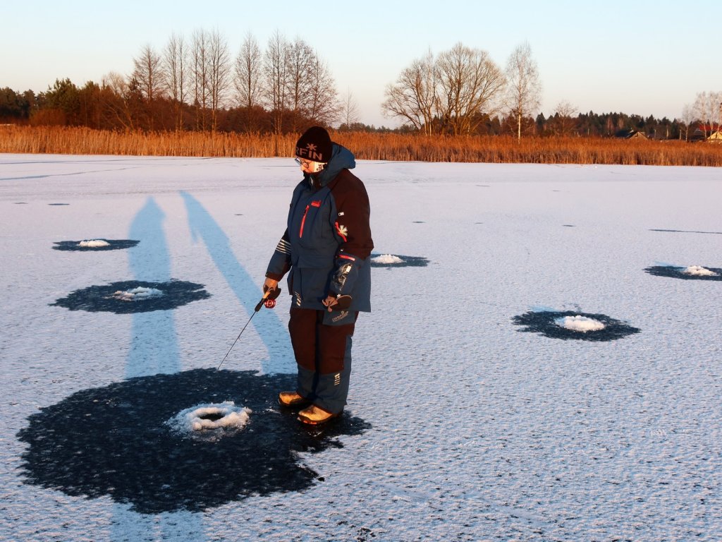 Рыбачка ловит на первом льду