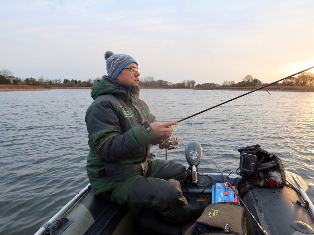 Спиннингист ловит с лодки