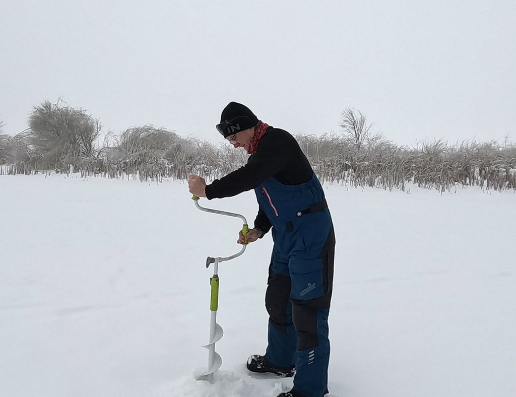 Рыболов бурит лунку