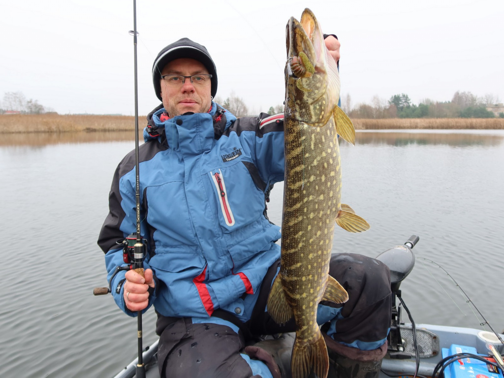 Спиннингист держит выловленную трофейную щуку