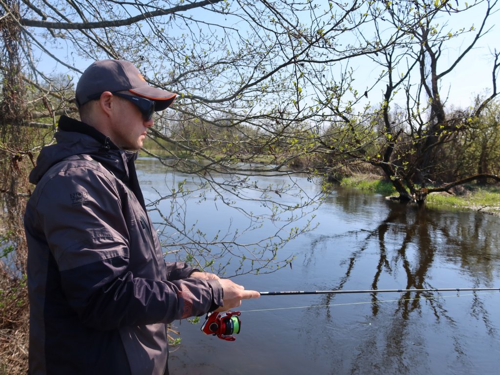 Рыболов ловит спиннингом на реке