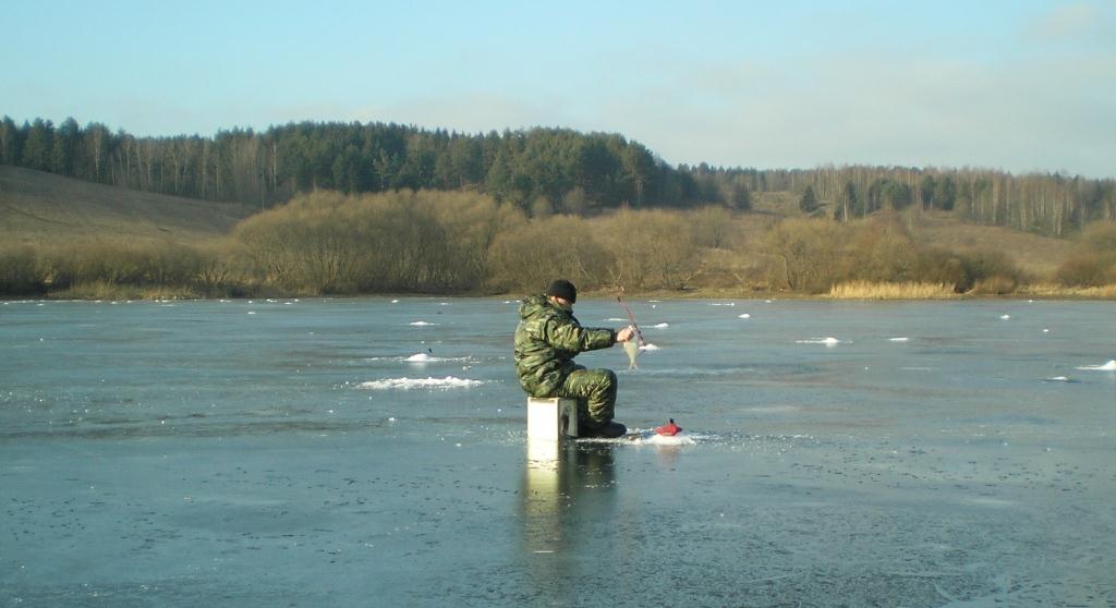 Рыбак ловит на чертика ясням зимним днем