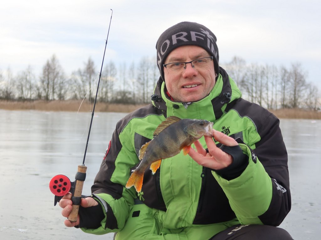 Валерий Сикиржицкий с окунем и удочкой на льду