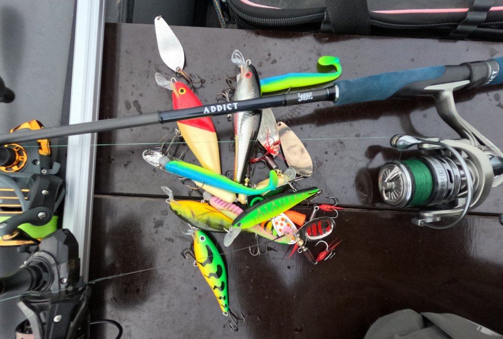 Разные приманки и спиннинг в лодке