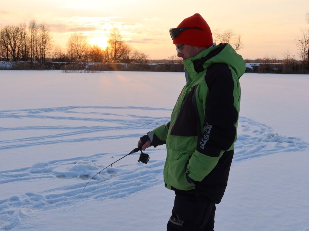 Рыболов ловит зимой стоя