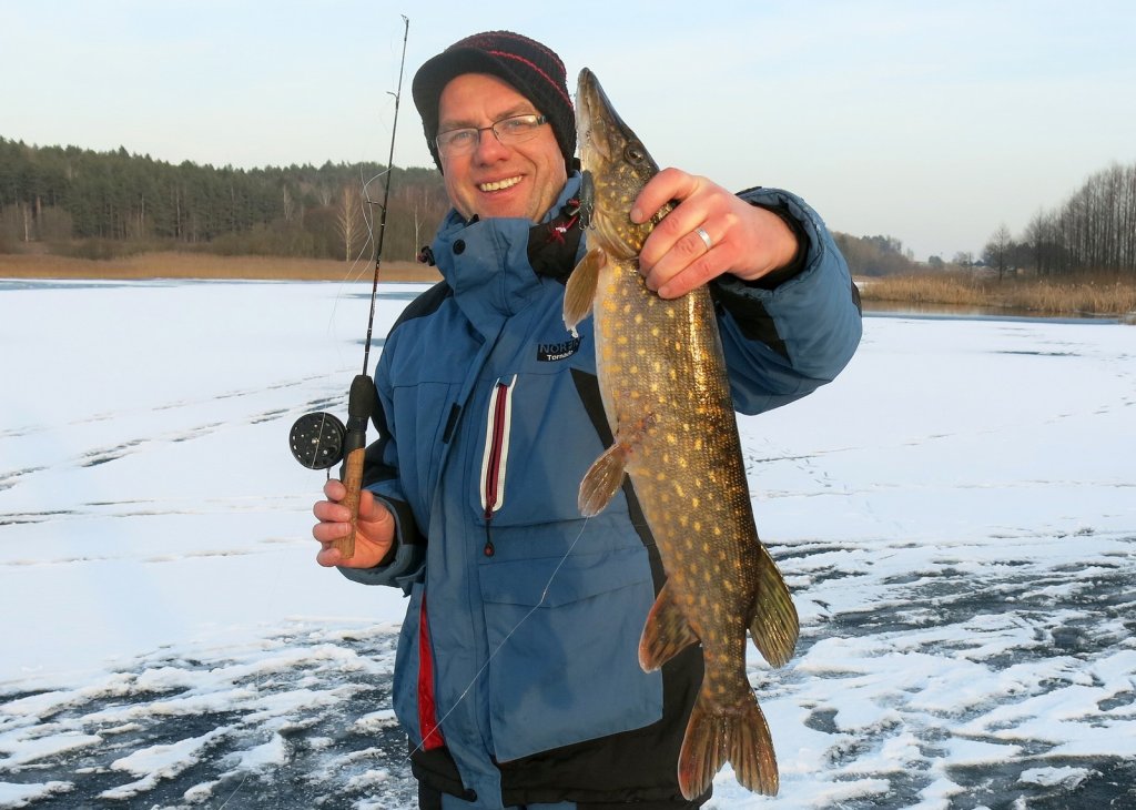 Валерий Сикиржицкий стоит со щукой на льду