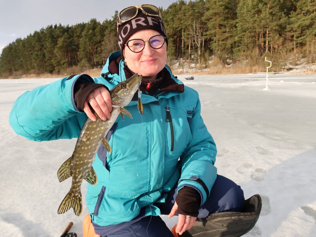 Рыбачка со щукой на льду