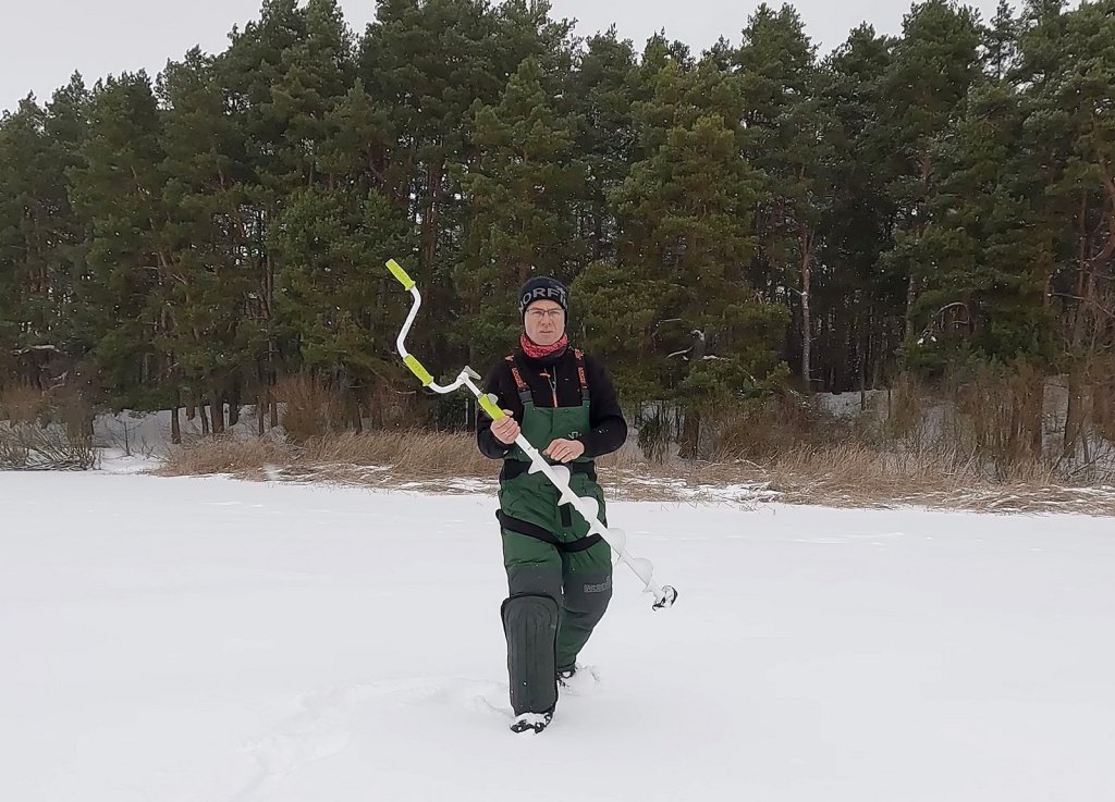 Рыболов идёт с ледобуром