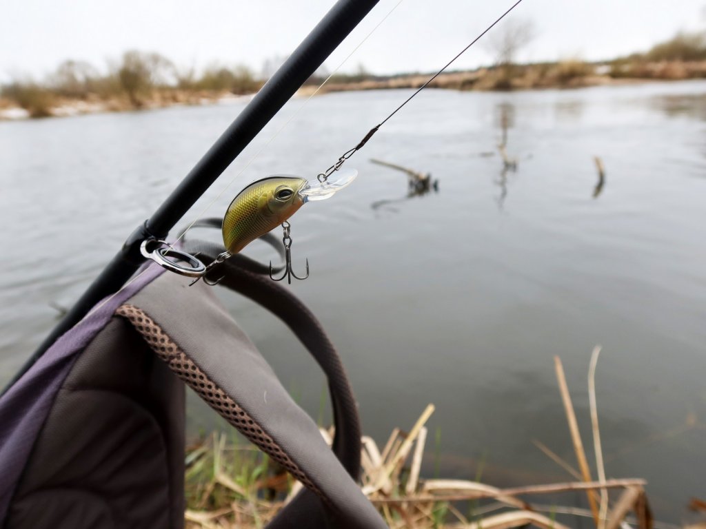 Воблер на снасти на фоне реки