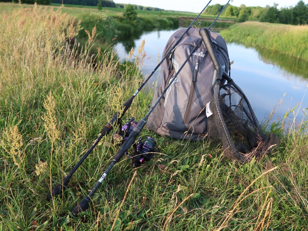 Спиннинги и рюкзак на берегу реки