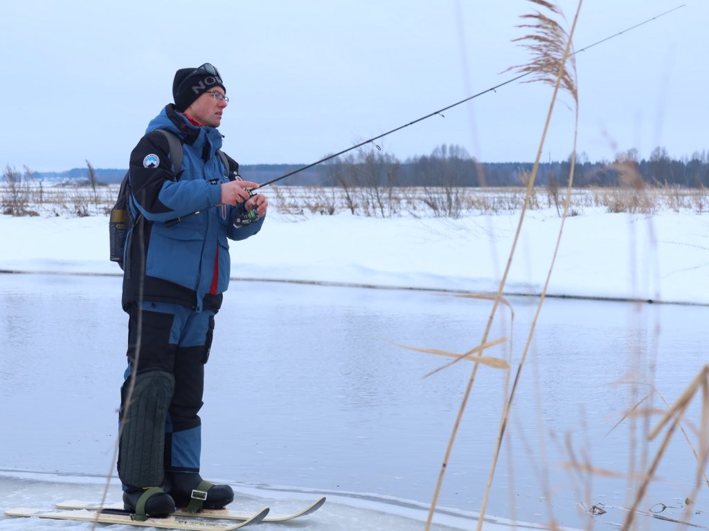Спиннингист ловит зимой на лыжах