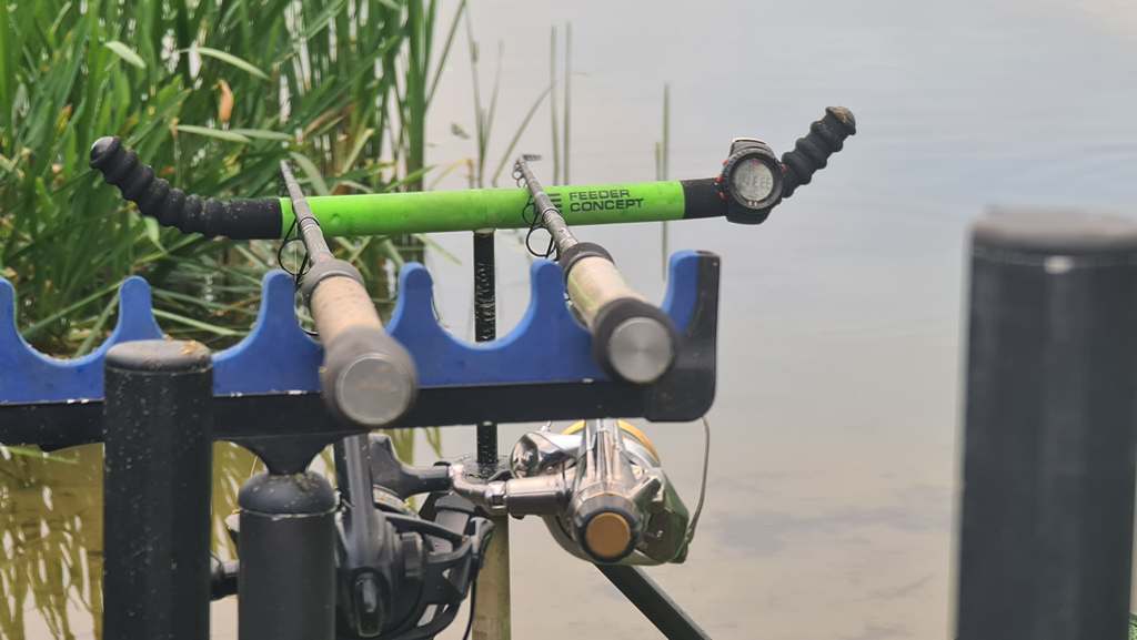 Два фидера лежат на подставке для удилищ