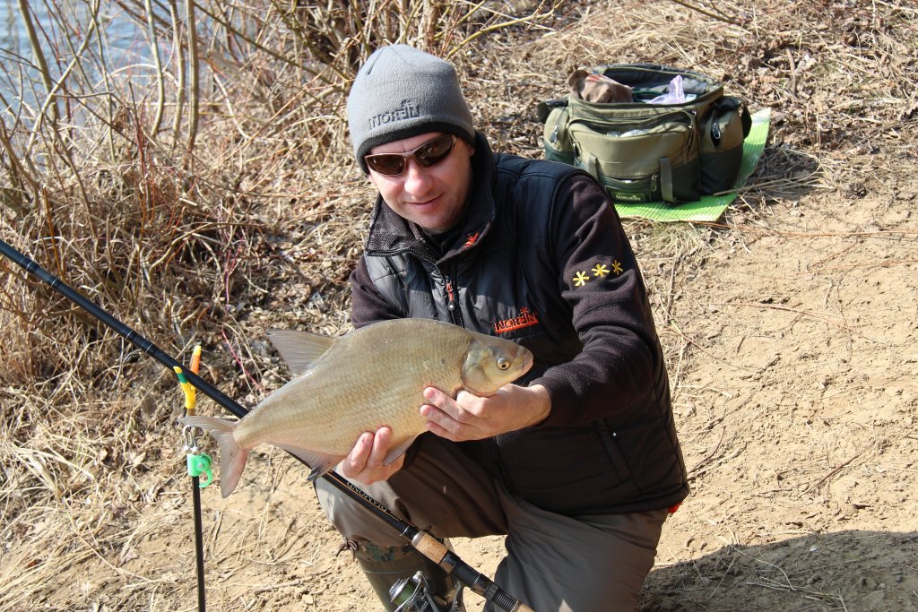 Рыболов с лещом, пойманным на фидер