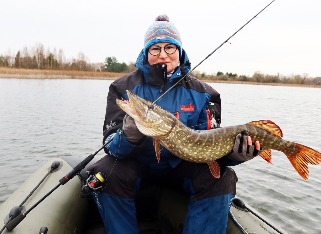 Рыбачка с хорошей щукой в лодке