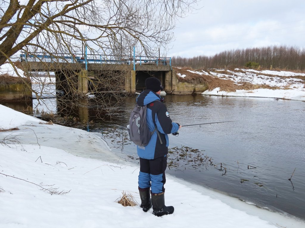 Спиннингист ловит возле шлюза