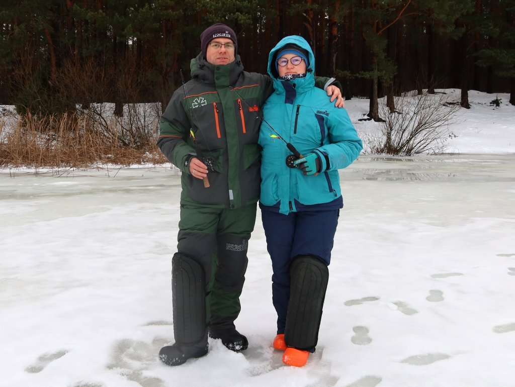 Рыболов и рыбачка на льду с удочками