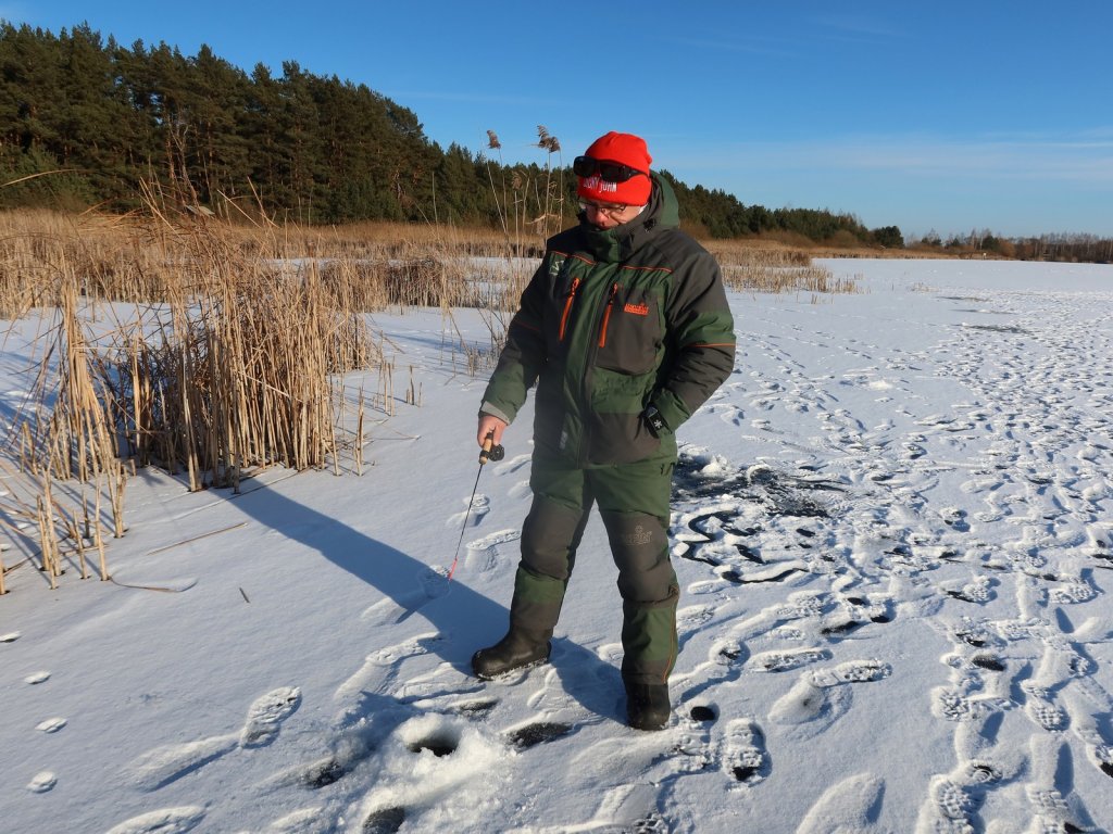 Рыболов ловит на льду стоя