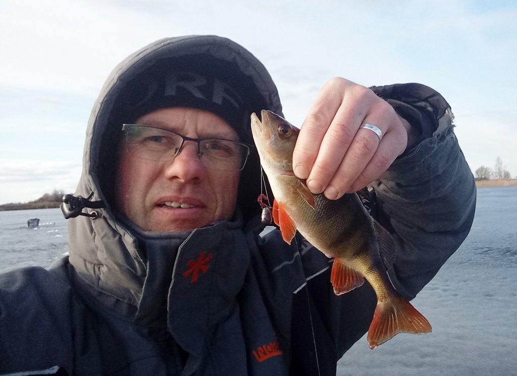 Рыбак показывает окуня, пойманного на балду