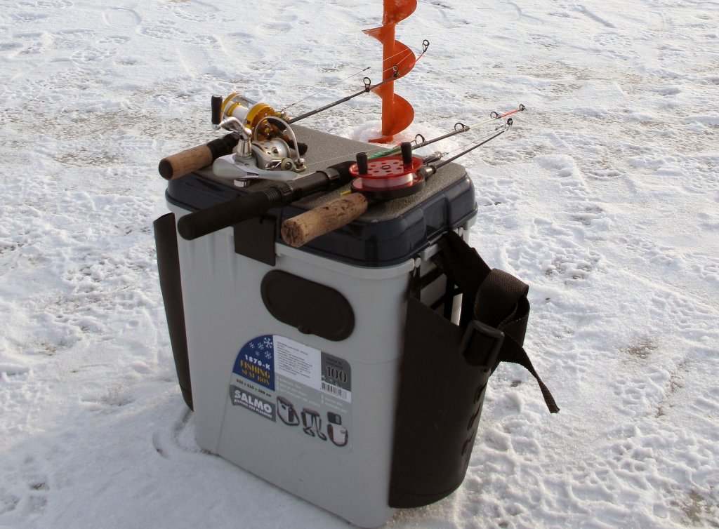 Зимние удочки лежат на ящике