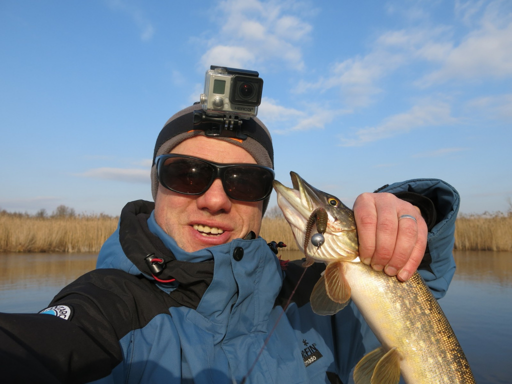 Рыбак позирует с небольшой щучкой