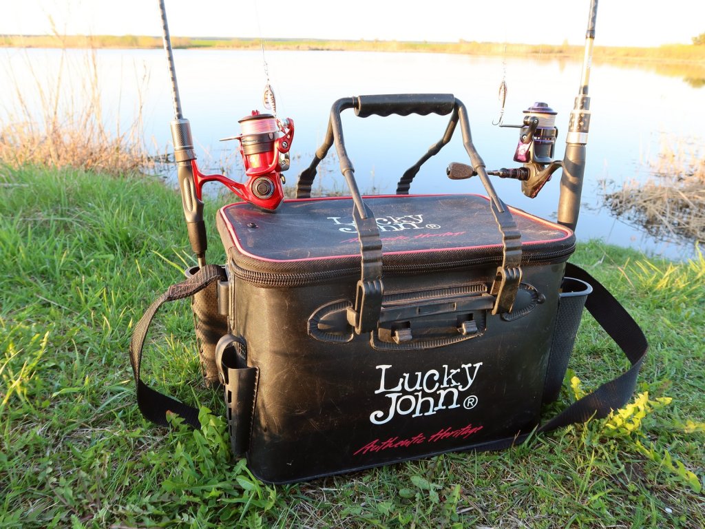 Спиннинговые снасти и сумка на берегу