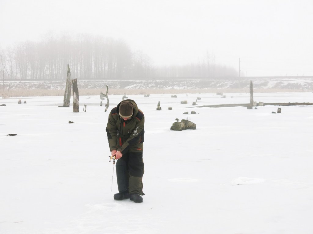 Рыболов зимой на закорчёванном водоёме