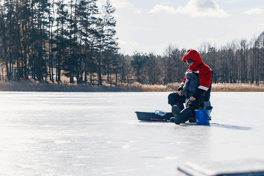 Рыблак ловит в солнечный день со льда