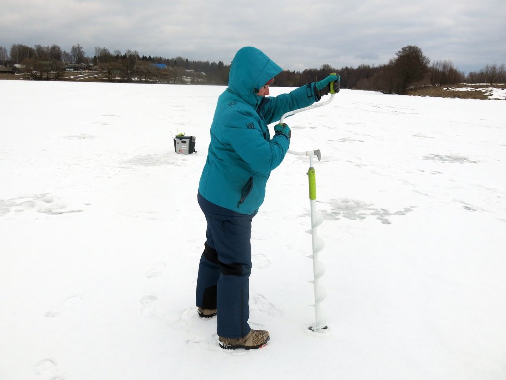 Рыбачка бурит лунку