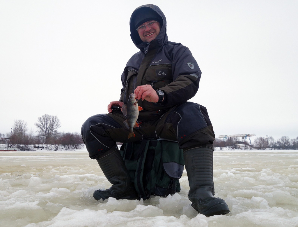 Рыбак с пойманным на безмотылку окунем