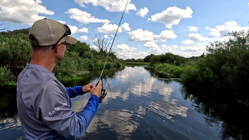 Спиннингист делает заброс на реке Спиннингист делает заброс на реке