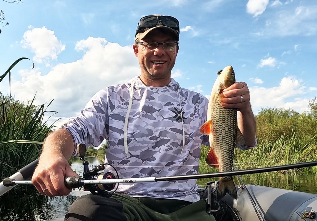 Валерий Сикиржицкий в лодке с голавлём и спиннингом