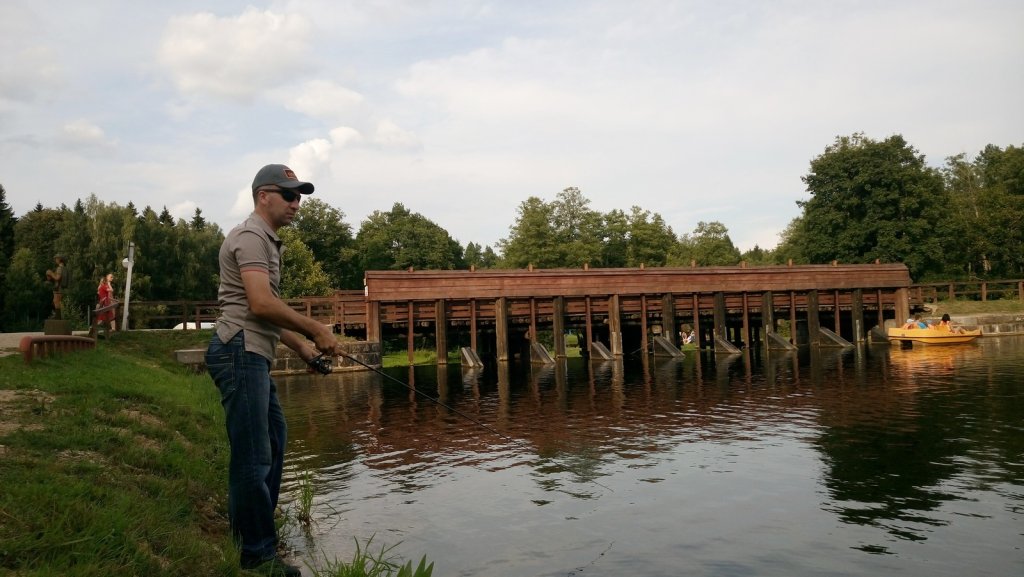 Спиннингист рыбачит возле плотины