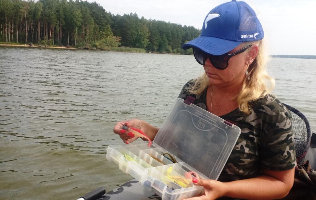 Женщина-рыболов выбирает приманку для ловли