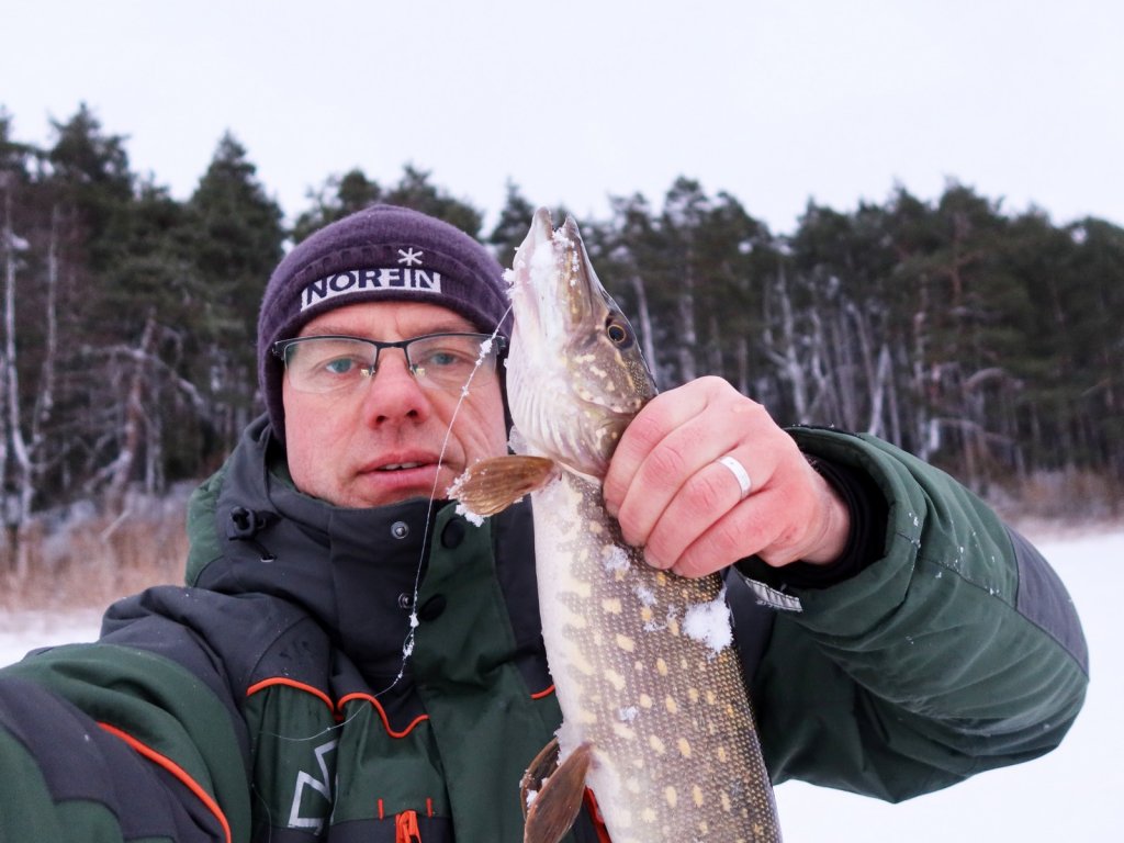 Валерий Сикиржицкий со щукой зимой на лесном водоёме