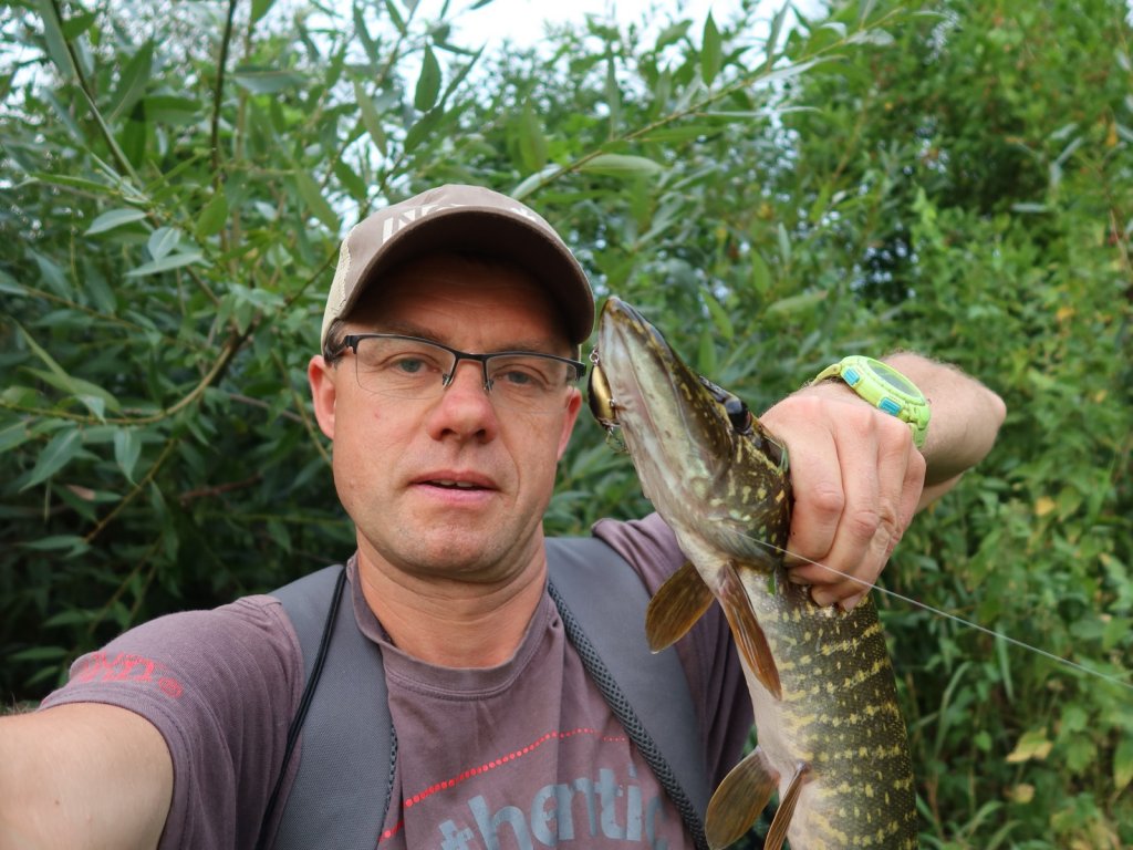 Рыболов со щукой, пойманной на маленький воблер