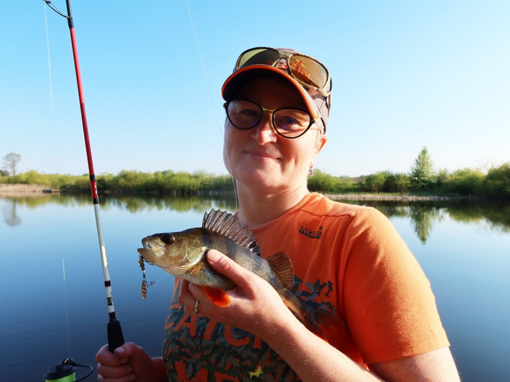 Довольная рыбачка с окунем