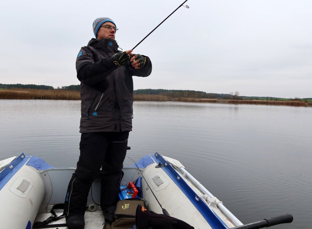 Рыболов ловит спиннингом с лодки