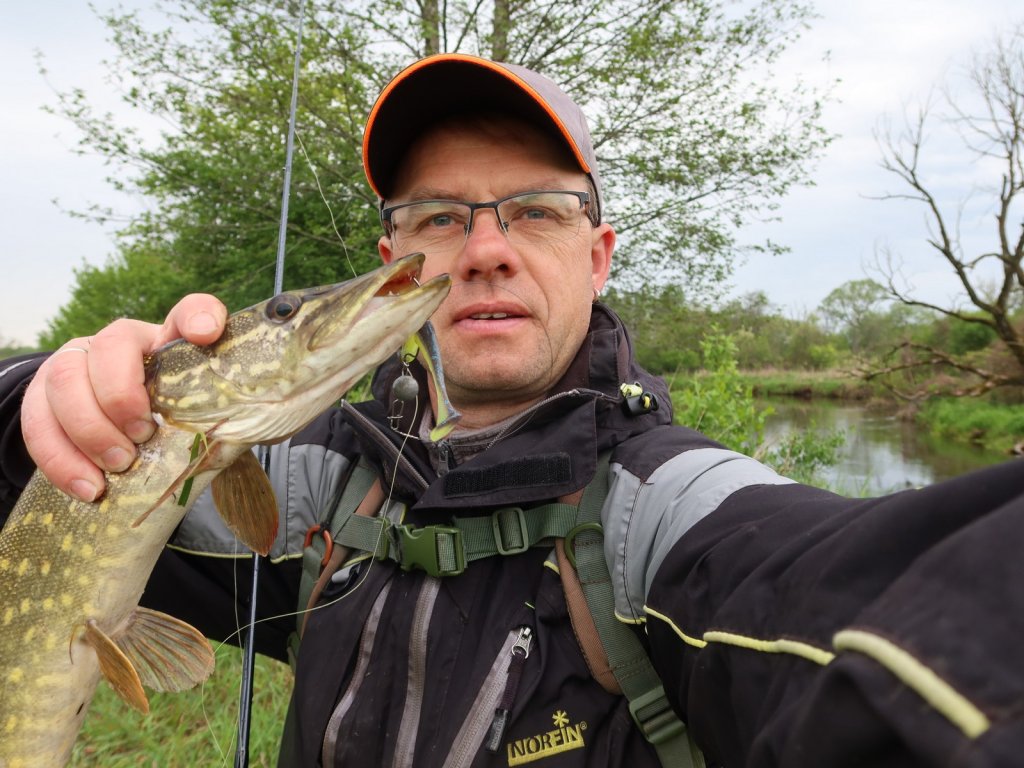 Валерий Сикиржицкий с весенней щукой на фоне речки