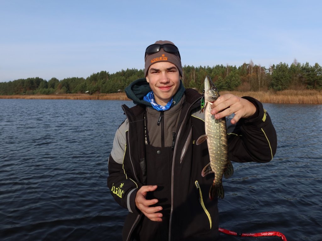 Юный рыболов держит щуку