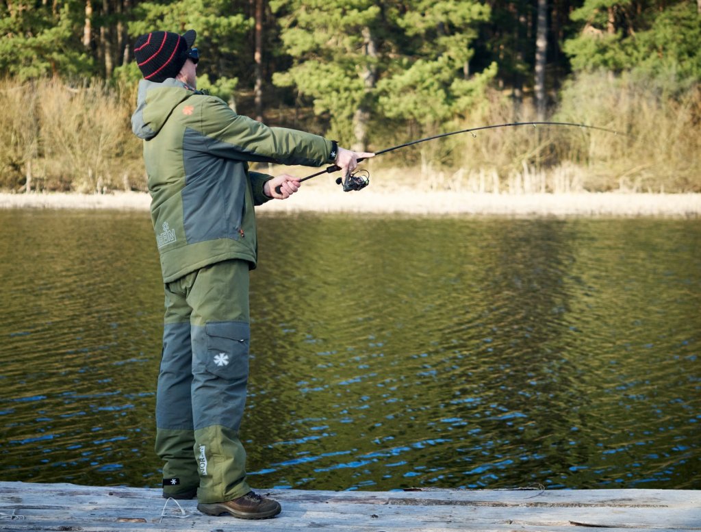 Рыболов делает спиннинговый заброс Рыболов делает спиннинговый заброс