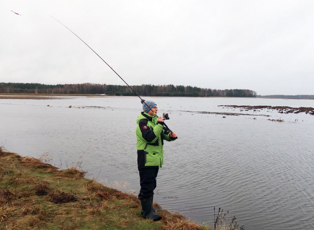 Рыболов делает заброс спиннингом