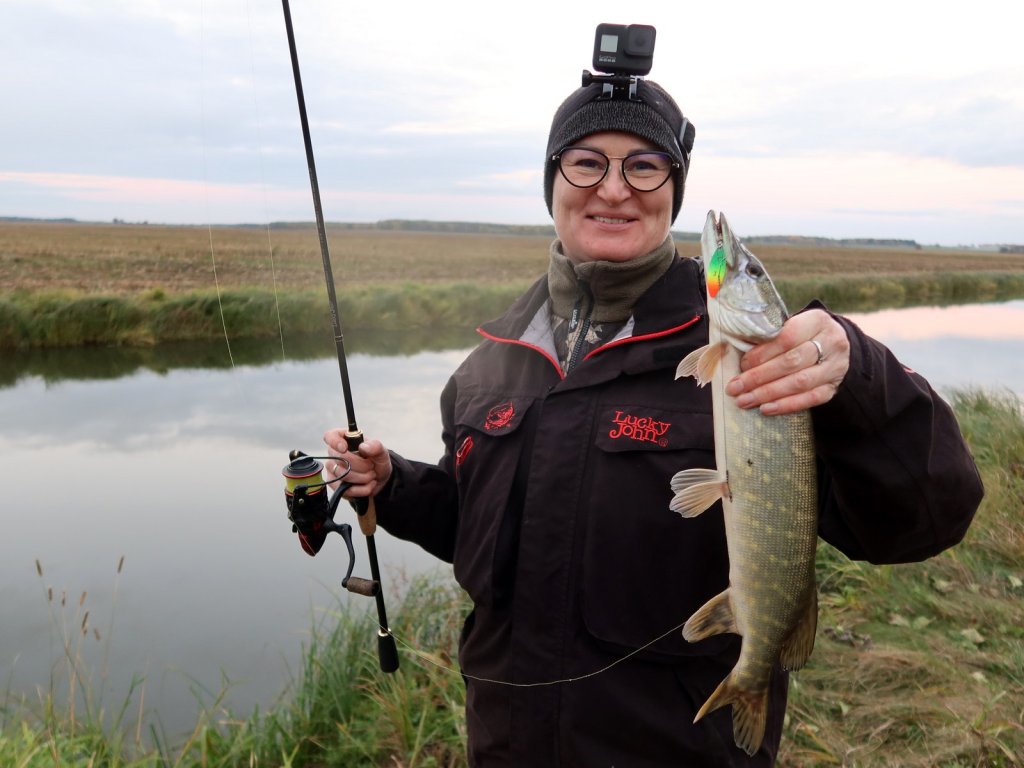Довольная рыбачка со щукой на канале