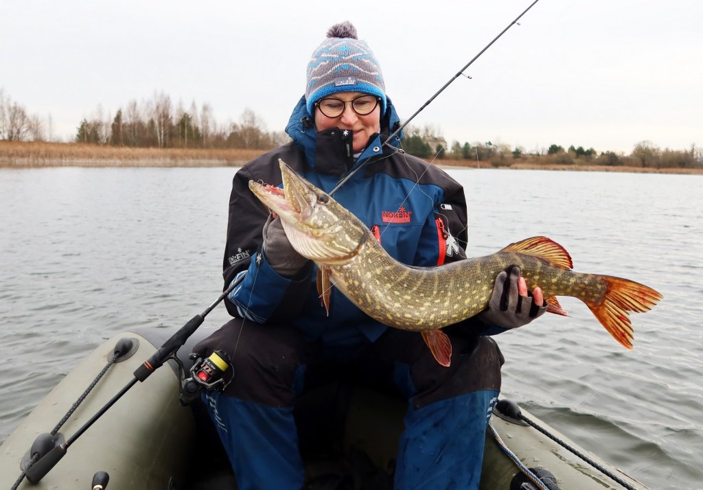 Рыбачка с крупной щукой в лодке