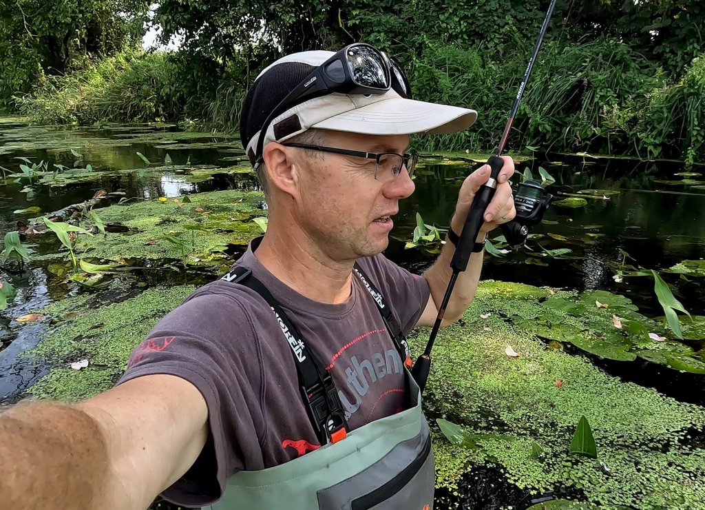 Рыболов в забродном костюме на реке