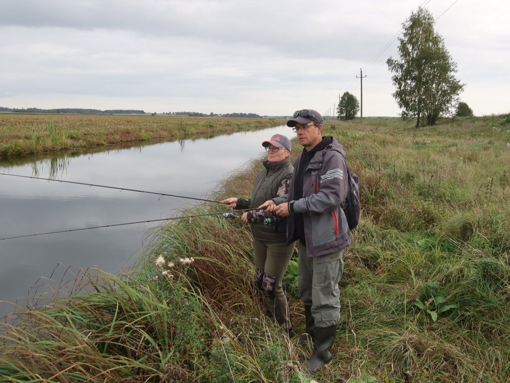 Рыболов и рыбачка ловят спиннингом