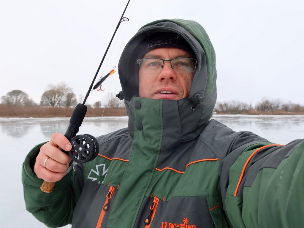 Рыболов на балансирной рыбалке в зимнюю оттепель