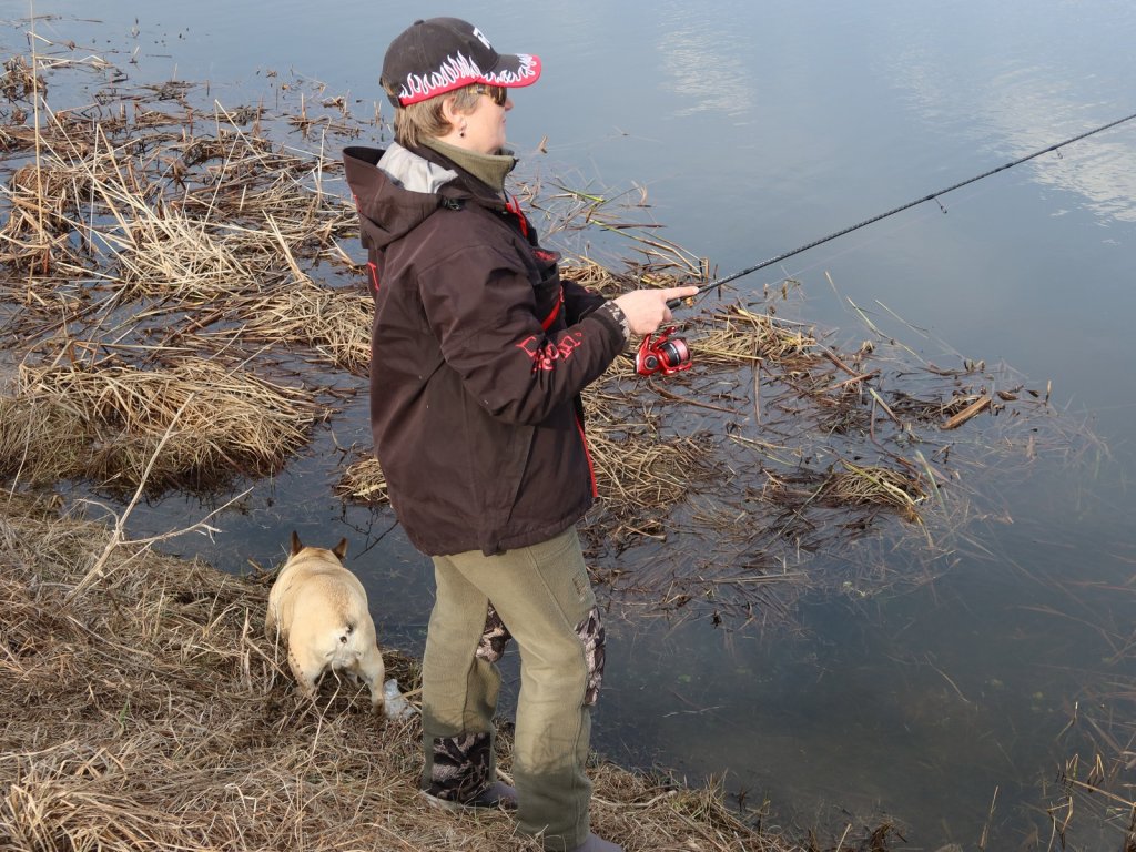 Рыбачка ловит спиннингом с берега
